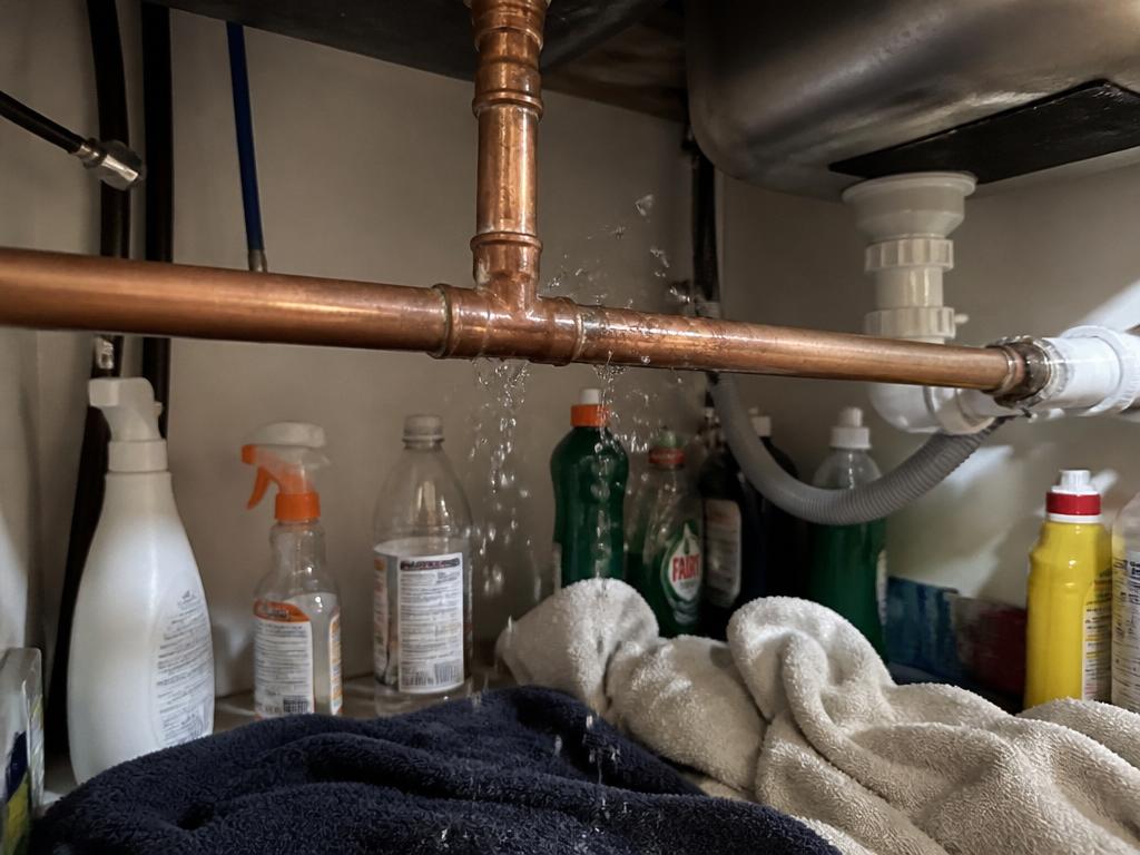 Leaking copper pipe under a kitchen sink during a Bournemouth plumbing emergency